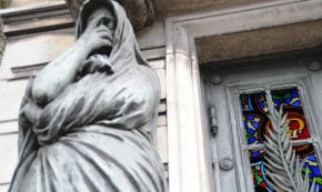 Statue in grief, stained glass,
