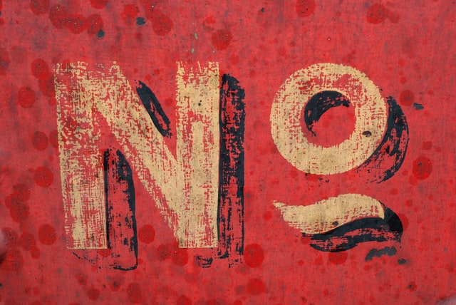 The word "No" painted on a red field, photo of vintage sign work.