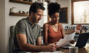 Cropped shot of an affectionate young couple going through paperwork at home