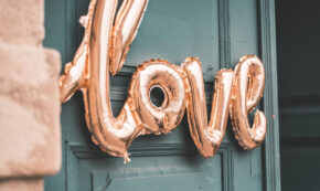 Love shaped balloons in front of wooden door