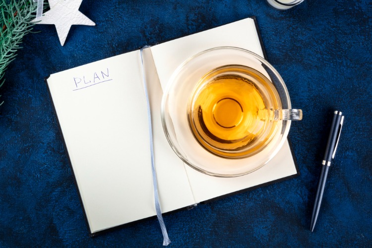 Photo of a to do list next to a cup of tea, a symbol of a new year's resolutions