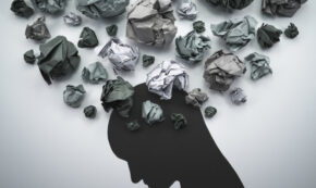 Concept image of anxiety and negative emotion filling the brain. Waste paper filling head silhouette.