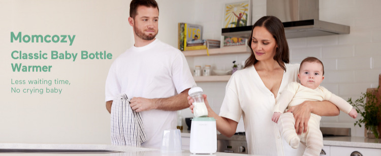 Image shows two parents in their kitchen. Mom is holding a baby and putting a bottle into a Momcozy Baby Bottle Warmer while Dad watches.