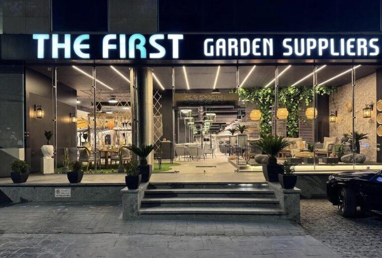 Exterior view of The First Garden Suppliers showroom, featuring outdoor furniture displays and green wall installations.